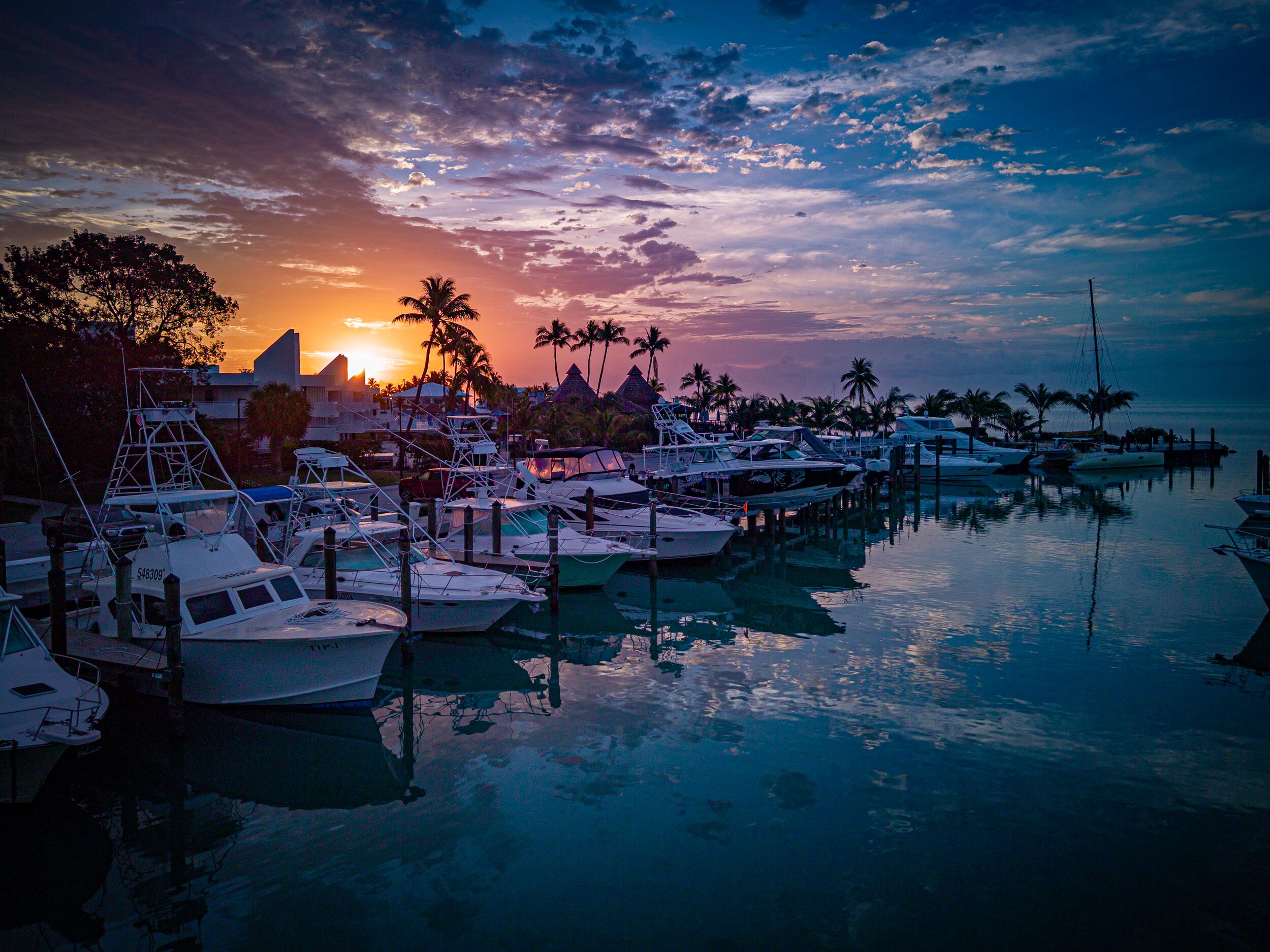 Boats parked at Caloosa Cove Marina in Florida at sunset.